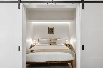 a bedroom with white walls and a bed with white sheets at Urban Elegance | Espadin LoHi in Denver