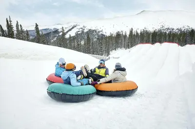 a group of people riding on a tube in the snow at Luxury Home - Sleeps 10 - Fireplace & Mountain View condo in Keystone