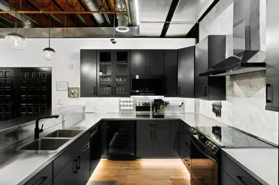 a kitchen with black and white cabinets and a sink at Suite No 1 & No 2 in Denver