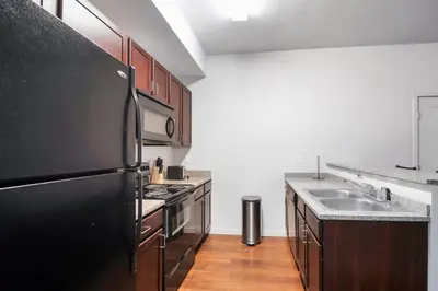 a kitchen with a black refrigerator and a sink at Welcoming Hideaway Near UNC & Downtown in Greeley