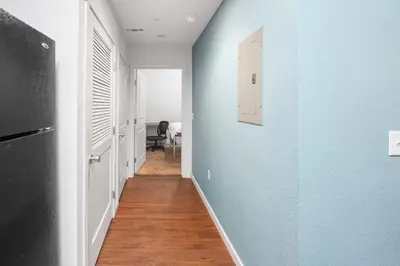a hallway with blue walls and wooden floors at Central Urban Stay with Gym in Greeley