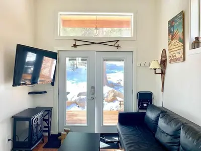 a living room with a couch and a sliding glass door at Skiers Cabin at Base Camp Lodging Company in Dumont