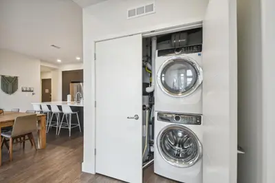 a kitchen and living room with a washer and dryer at Sleek & Chic Comforts at Espadin in Denver