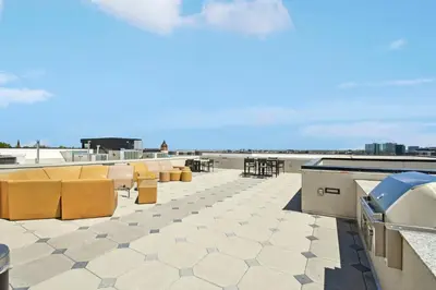 a patio with yellow chairs and tables on a roof at 2880 Skyline Penthouse at Espadin in Denver