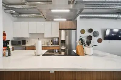 a kitchen with white cabinets and a counter top at 3198 Industrial Chic at RiNo Art Lofts in Denver