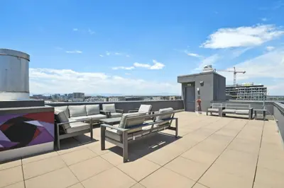 a rooftop deck with benches and a view of a city at 3198 Urban Cowboy Escape at RiNo Art Lofts in Denver