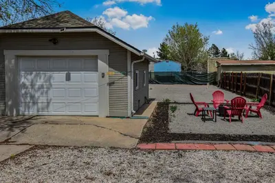 a garage with red chairs and a table next to it at 3 bed home with huge yard near Hidden Lake in Denver