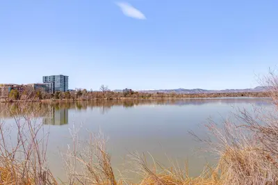 a large body of water with a city in the background at Luxe Designer Flat on Sloans Lake with Rooftop Deck in Denver