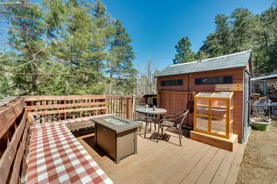 a wooden deck with a table and a kitchen on it at 8 Mi to Rocky Mountain Natl Park Serene Escape in Drake