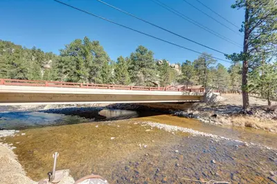 a bridge over a river next to a river at Fish, Hike and Unwind Drake Cabin with Hot Tub! in Drake