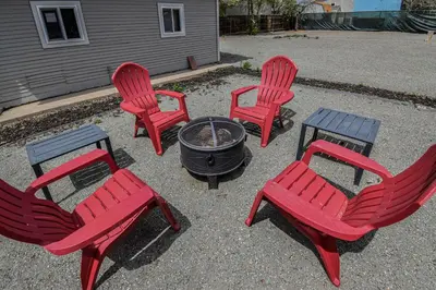 a group of four red chairs and a fire pit at Fun and Affordable Dual Bedroom Lower Unit in Vibrant Denver in Denver