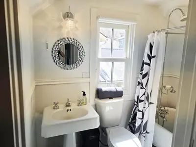 a bathroom with a sink and a toilet and a mirror at Historic 4 bedroom Victorian Home in Downtown Georgetown in Georgetown