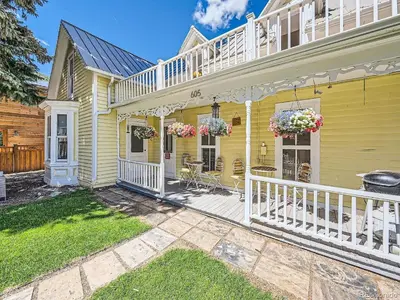 a yellow house with white railings and a porch at Victorian Dream! Charming Mountain View Home by Downtown in Georgetown