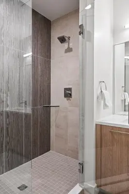a shower with a glass door in a bathroom at Mile High Muse Lifestyle Loft Espadin LoHi in Denver