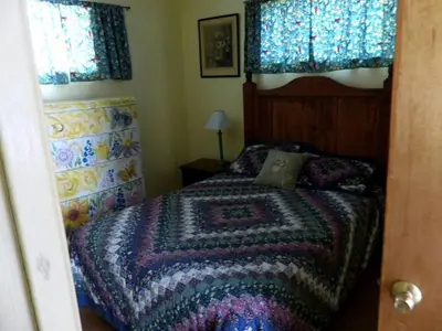 a bedroom with a bed with a colorful blanket at Rural Cabin Rental in Gorgeous Poudre Canyon near Fort Collins, Colorado in Fort Collins
