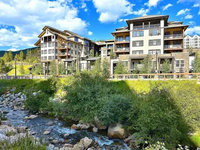 a large apartment building next to a river at Fraser Crossing 3405 Ski In Ski Out Winter Park Resort in Winter Park