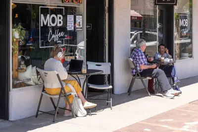 two people sitting at a table in front of a store at Spacious and Quiet Retreat - Firepit and Yard in Denver