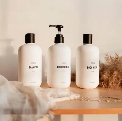three bottles of shampoo and conditioner sitting on a table at Wellness Retreat - Sauna Cold Plunge & Hot Tub in Broomfield