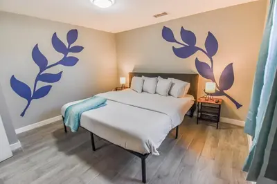 a bedroom with a bed with blue flowers on the wall at Entire Family Home in Denver in Denver