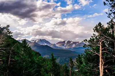 a view of a mountain range with trees and clouds at Shady Grove with 4 King Beds, Dog Run and Outdoor Fun in Loveland