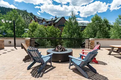 a patio with two chairs and a fire pit at Amenities Deck Level, Walk to Gondola WP Resort in Winter Park