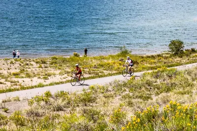 two people riding bikes on a path near the water at Red Hawk Lodge 2312 in Keystone