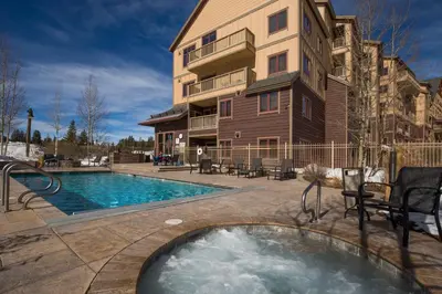 a house with a swimming pool next to a building at Red Hawk Lodge 2312 in Keystone