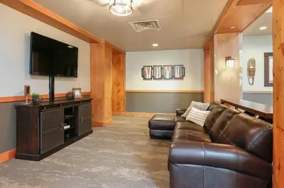 a living room with a leather couch and a flat screen tv at Expedition Station 8581 in Keystone