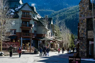 a group of people walking down a street in a ski resort at Expedition Station 8569 in Keystone
