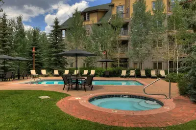 a pool with a table and chairs next to a building at Expedition Station 8571 in Keystone