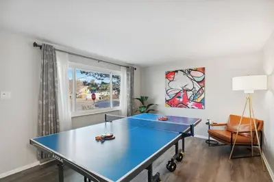a blue ping pong table in a room with a window at Family-friendly | Ping-Pong | Game Rm | Fast Wifi in Arvada