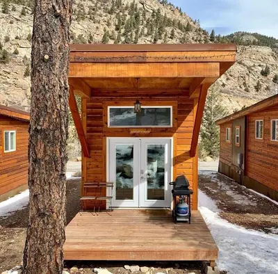 a log cabin with a porch and a door at Spring Gulch Cabin at Base Camp in Dumont