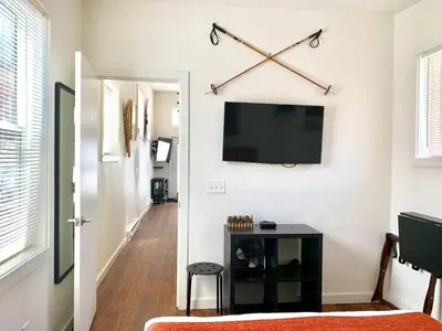 a living room with a flat screen tv on a wall at Spring Gulch Cabin at Base Camp in Dumont
