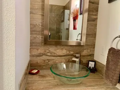 a bathroom with a glass bowl sink on the floor at Iron Horse Cabin at Base Camp Lodging Company in Dumont