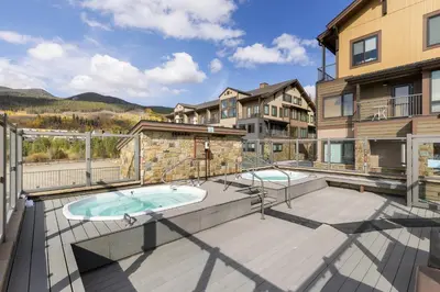 an outdoor patio with two hot tubs on a building at 2795 Slopeside condo in Keystone