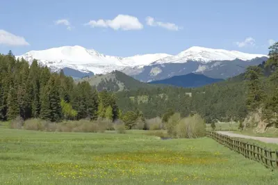 a field with snow capped mountains in the background at The Golden Townhouse Walk to downtown Pets Welcome in Golden