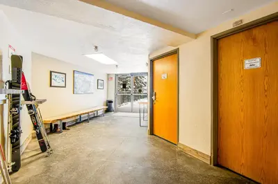 a hallway with a door and a room with skis at Iron Horse Resort 5064 in Winter Park
