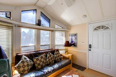 a living room with a leather couch and windows at #84 Tiger Run in Breckenridge