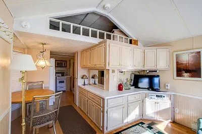 a kitchen with white cabinets and a table and a microwave at #84 Tiger Run in Breckenridge