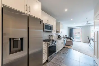a kitchen with a refrigerator and a stove top oven at Stylish Grand Lake Retreat - King Bed - Walk to Lake in Grand Lake