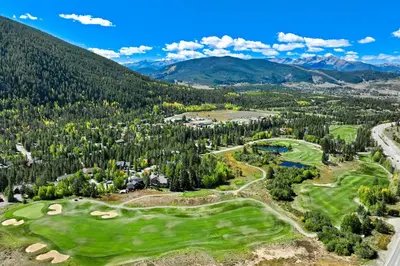 an aerial view of a golf course with mountains in the background at 1928 Soda Ridge in Keystone