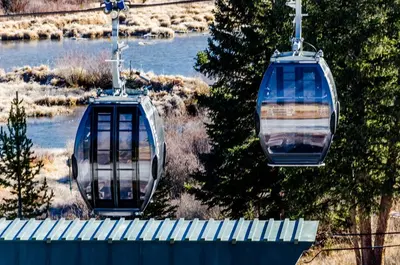 two cable cars are flying over a river at Brightwood 105 in Keystone