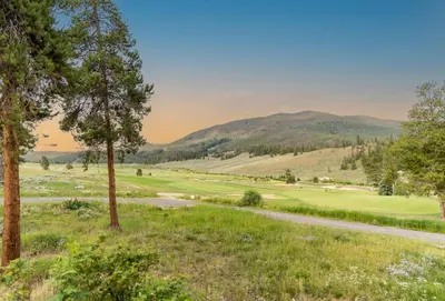 a view of a golf course with mountains in the background at Seasons at Keystone 1841 in Keystone