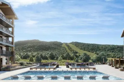 a large swimming pool with a view of a mountain at Kindred Resort Luxury Ski In, Ski Out 2 Bedroom Residence At The River Run Gondola in Dillon