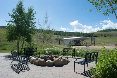 a fire pit in a park with two benches at Base Camp One 403 in Granby