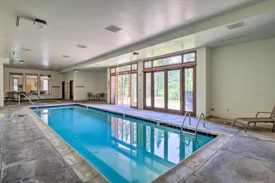 a large swimming pool with blue water in a building at Family Ski Trip! Upscale Keystone Condo Near Lift in Dillon