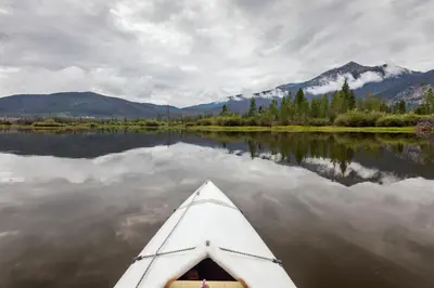 a kayak on a lake with mountains in the background at Highland Greens Retreat: Great Location, Near Shuttle Stops in Breckenridge