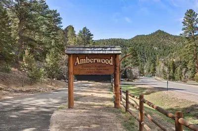 a sign for an antlerwood sign on the side of a road at Cabin 7- Studio Cabin Heated Floors 5 Min to RMNP in Estes Park
