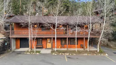 an orange house with trees in front of it at Cabin 7- Studio Cabin Heated Floors 5 Min to RMNP in Estes Park
