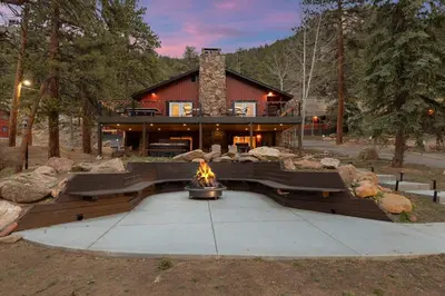 a house with a fire pit in front of it at Cabin 14 - King Bed hotel-style unit in Estes Park